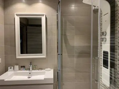 a bathroom with a sink and a shower with a mirror at Two bedroom Fragonard Cannes in Cannes