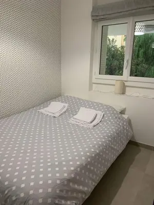 a bed with two towels on it in a room with a window at Two bedroom Fragonard Cannes in Cannes