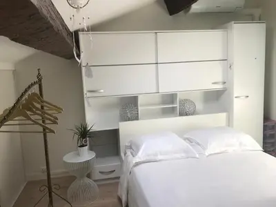 a bedroom with a white bed and a white cabinet at Inn CLOUDS Cannes in Cannes