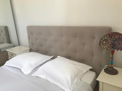 a bed with white pillows and a headboard at Inn CLOUDS Cannes in Cannes