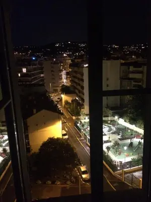 a view of a city at night from a window at Inn CLOUDS Cannes in Cannes