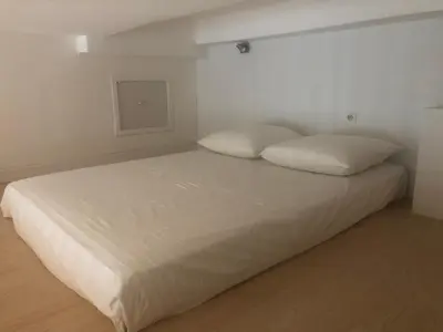 a bed with white sheets and pillows in a room at Vieux port de Cannes in Cannes