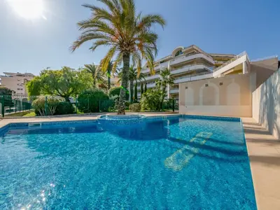 a swimming pool in a villa with a palm tree at Apartment Riviera Park-1 by Interhome in Cannes