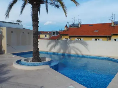 a palm tree sitting next to a swimming pool at Apartment Riviera Park-1 by Interhome in Cannes