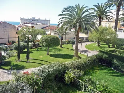 a park with palm trees and grass and bushes at Apartment Riviera Park-1 by Interhome in Cannes