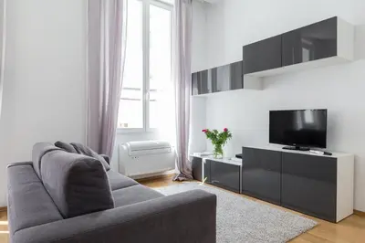 a living room with a couch and a flat screen tv at Le St Honoré in Cannes