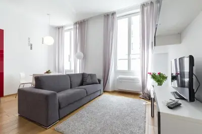 a living room with a couch and a tv at Le St Honoré in Cannes