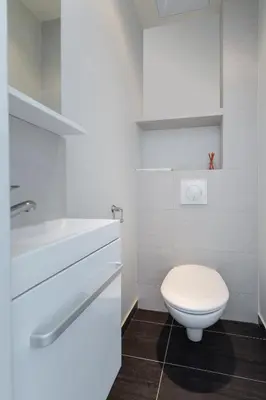 a white bathroom with a toilet and a sink at Le St Honoré in Cannes