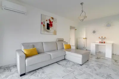 a white living room with a couch and a table at Superb 1 bedroom appartement - close to Croisette in Cannes