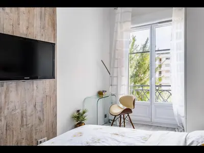 a bedroom with a bed and a tv on a wall at Cannes Croisette Concorde Miramar in Cannes