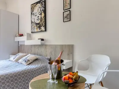 a bedroom with a bed and a table with a bowl of fruit at Cannes Croisette Concorde Miramar in Cannes