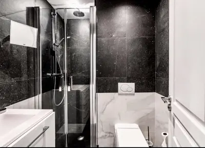 a black and white bathroom with a shower and a toilet at Cannes Croisette Concorde Miramar in Cannes