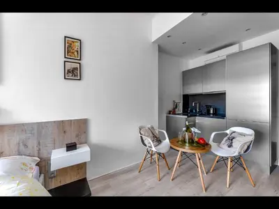 a bedroom with two chairs and a table and a kitchen at Cannes Croisette Concorde Miramar in Cannes