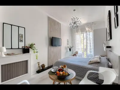 a bedroom with a bed and a table with a bowl of fruit at Cannes Croisette Concorde Miramar in Cannes
