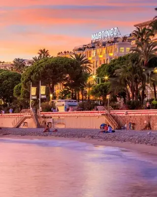 a view of a beach with a hotel in the background at Le Salvator in Cannes