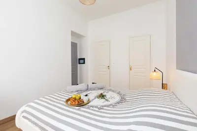 a white bed with a plate of fruit on it at 2 rooms apartment, near the sea and local market in Cannes