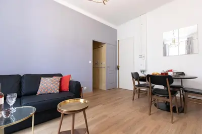 a living room with a black couch and a table at 2 rooms apartment, near the sea and local market in Cannes