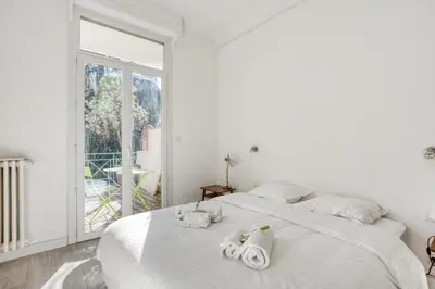 a white bedroom with a large bed with towels on it at IMMOGROOM - EXCLUSIVE - Terrace - Amazing quiet place - Wifi in Cannes