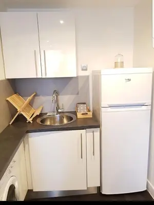 a kitchen with a sink and a white refrigerator at Studio Cosy centre Cannes in Cannes