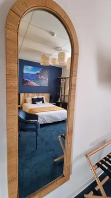 a large mirror in a bedroom with a bed at Charlie's Hôtel Cannes in Cannes