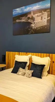 a bed with two pillows and a painting on the wall at Charlie's Hôtel Cannes in Cannes