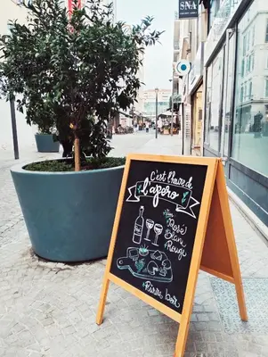 a chalkboard sign sitting on a sidewalk next to a tree at Charlie's Hôtel Cannes in Cannes