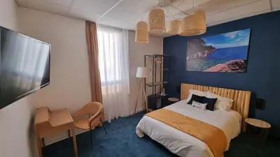 a hotel room with a bed and a flat screen tv at Charlie's Hôtel Cannes in Cannes