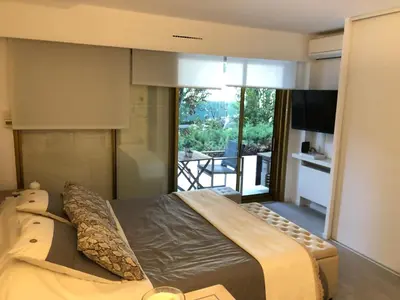 a bedroom with a large bed and a balcony at Luxe apartment center 6pers 300m2 privare garden in Cannes