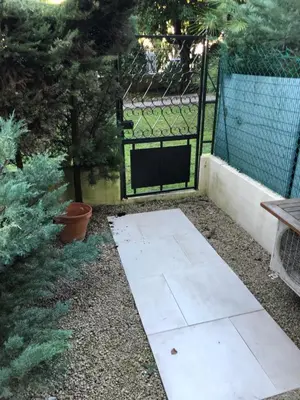 a garden with a black gate and a table and plants at Luxe apartment center 6pers 300m2 privare garden in Cannes