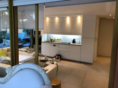 a kitchen with white cabinets and a living room at Luxe apartment center 6pers 300m2 privare garden in Cannes