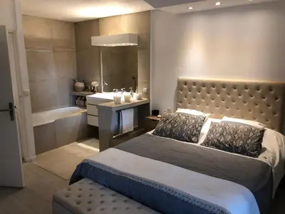 a bedroom with a bed and a tub and a sink at Luxe apartment center 6pers 300m2 privare garden in Cannes
