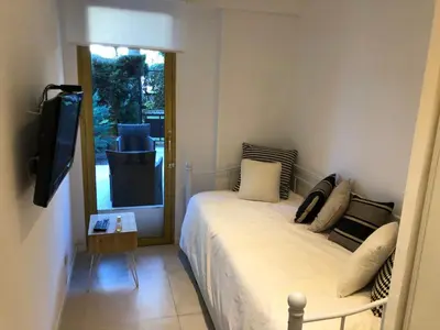 a small bedroom with a bed and a television at Luxe apartment center 6pers 300m2 privare garden in Cannes