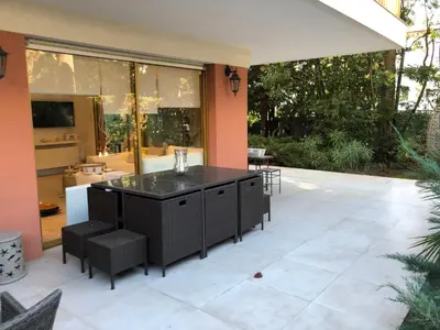 an outdoor patio with a bar and chairs at Luxe apartment center 6pers 300m2 privare garden in Cannes