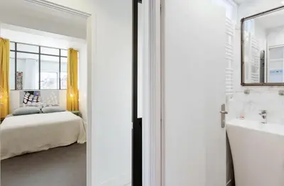 a bedroom with a bed and a sink and a mirror at CANNES Festival Films Center, with 2 bedrooms and balcony in Cannes