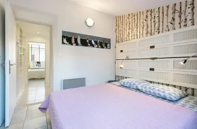 a bedroom with a purple bed and a bathroom at CANNES Festival Films Center, with 2 bedrooms and balcony in Cannes