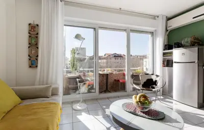 a living room with a couch and a large window at CANNES Festival Films Center, with 2 bedrooms and balcony in Cannes