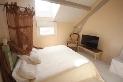 a bedroom with a white bed and a television at carré d'or rue d'ANTIBES à quelques pas du palais des Festivals in Cannes
