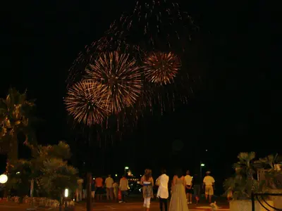 a group of people standing in front of a fireworks display at carré d'or rue d'ANTIBES à quelques pas du palais des Festivals in Cannes