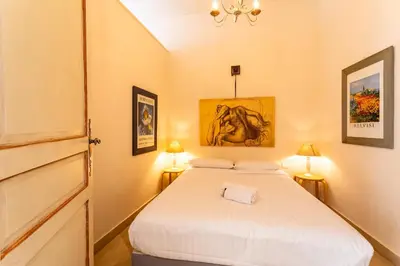 a small bedroom with a bed and two lamps at Frères Pradignac in Cannes