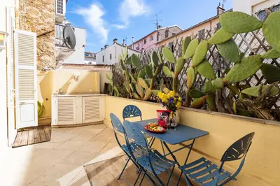 a table and chairs on a balcony with a cactus at Frères Pradignac in Cannes