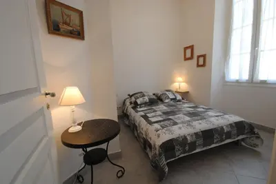 a bedroom with a bed and a table with a lamp at Frères Pradignac in Cannes