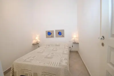 a bed in a white room with two lamps at Frères Pradignac in Cannes