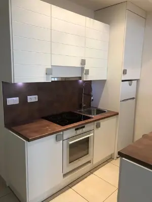a kitchen with white cabinets and a stove and a sink at Ô Palais des Iles Two Bedroom Cannes in Cannes