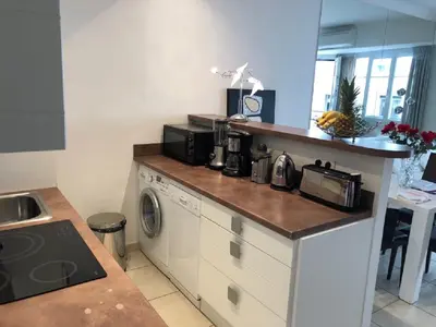 a kitchen with a counter with a microwave and a washer at Ô Palais des Iles Two Bedroom Cannes in Cannes