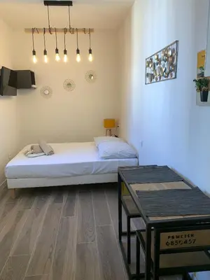 a bedroom with a bed and a table in it at Studio Vagliano in Cannes