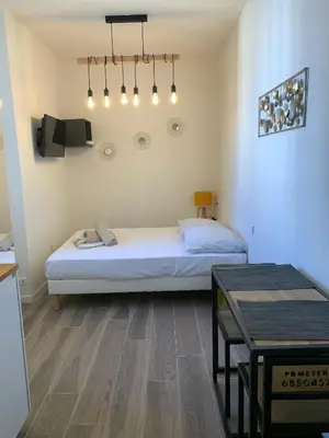 a bedroom with a bed and a table in it at Studio Vagliano in Cannes