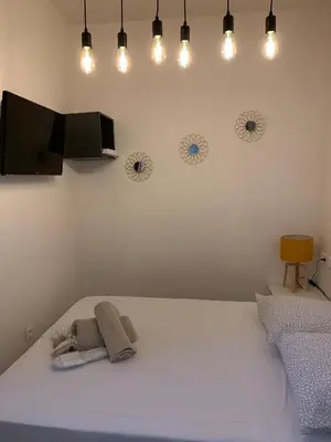 a bedroom with a white bed with lights on the wall at Studio Vagliano in Cannes