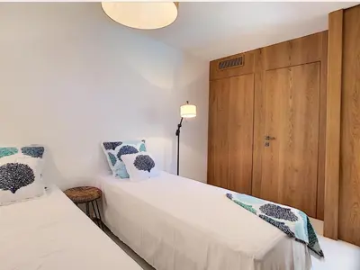 a bedroom with two beds and a wooden door at Villa Riviera in Cannes