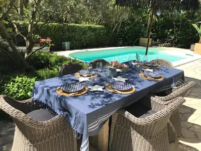 a table set for a meal by a swimming pool at Villa Riviera in Cannes