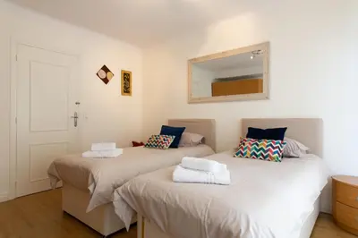 two beds in a room with a mirror on the wall at 2-Br Apartment 2 min from the Beaches in Cannes